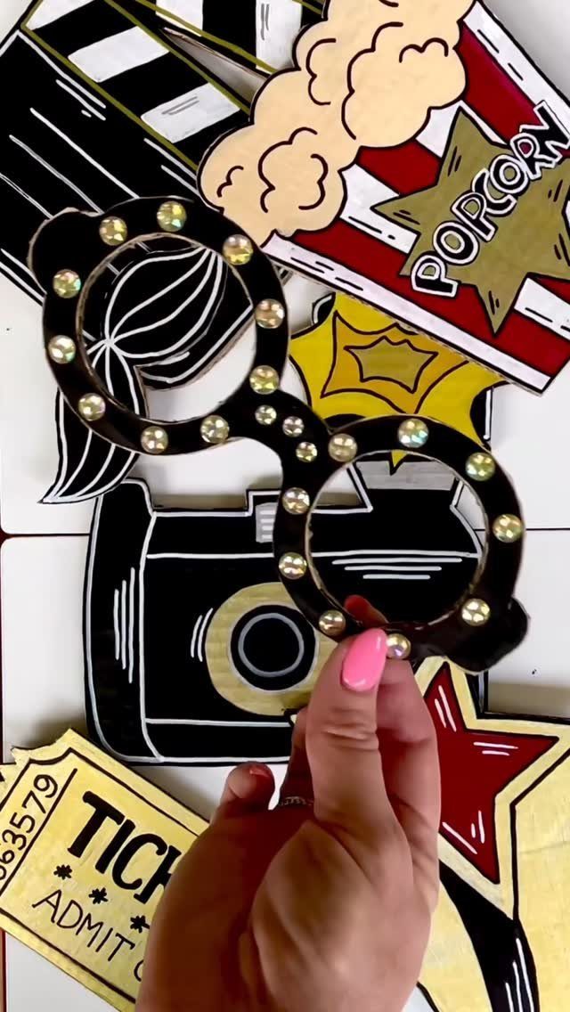 Novelty movie-themed photo booth props including glasses, popcorn, and a clapperboard.