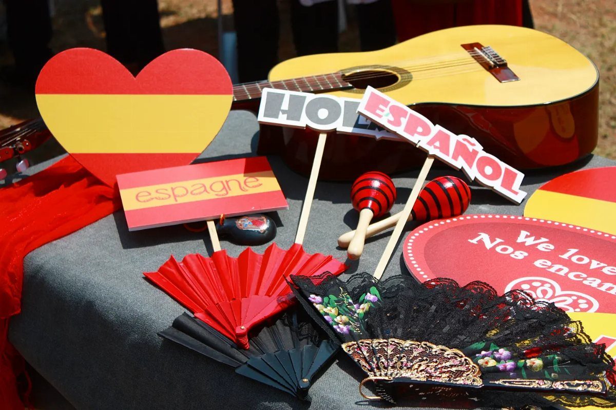 Spanish-themed photo booth props including signs, maracas, fans, and a classical guitar.