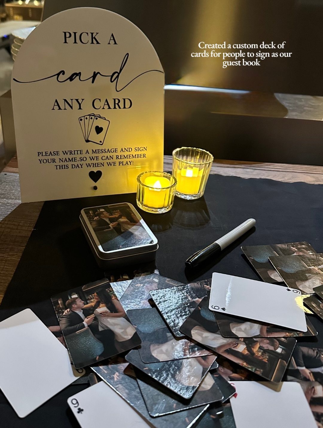 Custom playing cards and a sign for a guest book at a party.