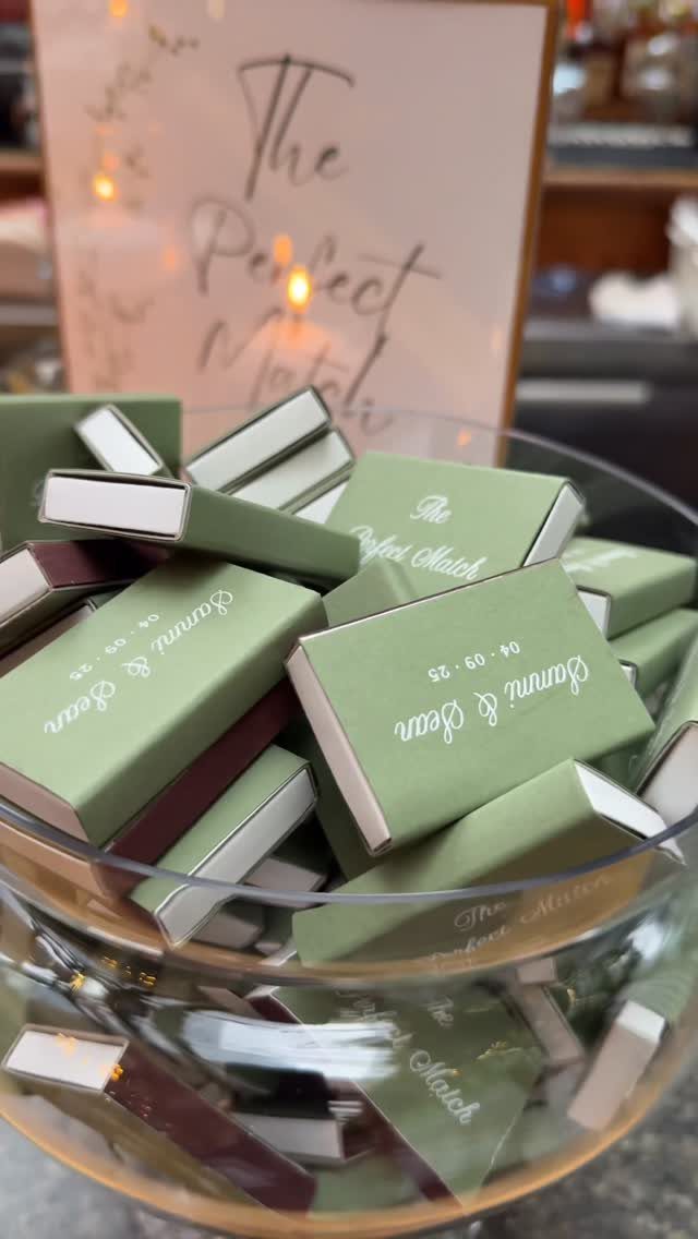 Sage green matchboxes in a glass bowl with a Perfect Match sign behind.