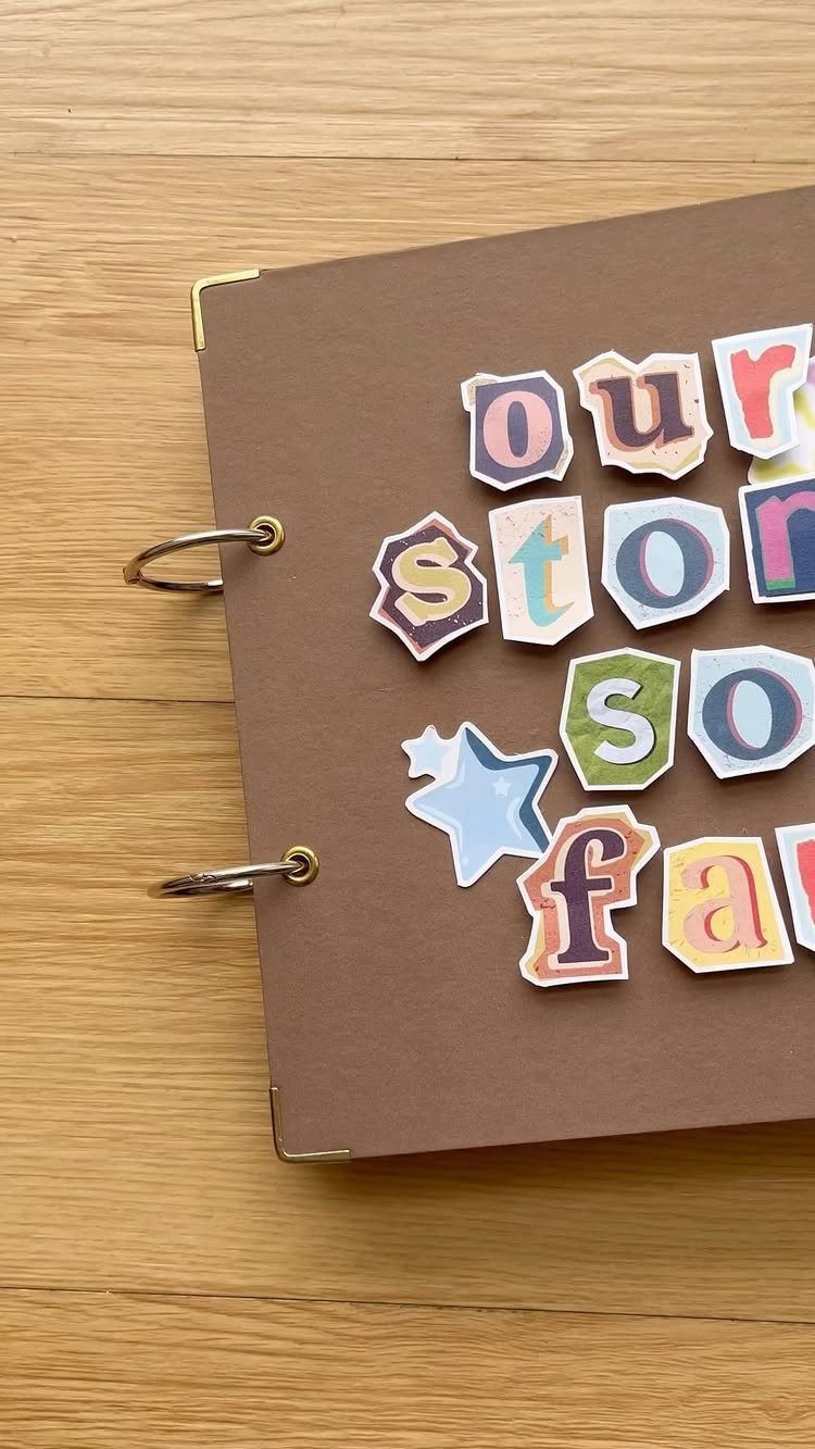 Brown scrapbook cover with colorful cutout letters spelling our story so far