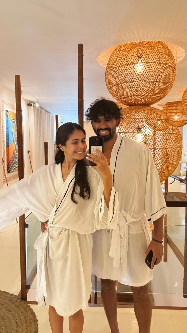 Couple in white robes taking a mirror selfie in a spa setting