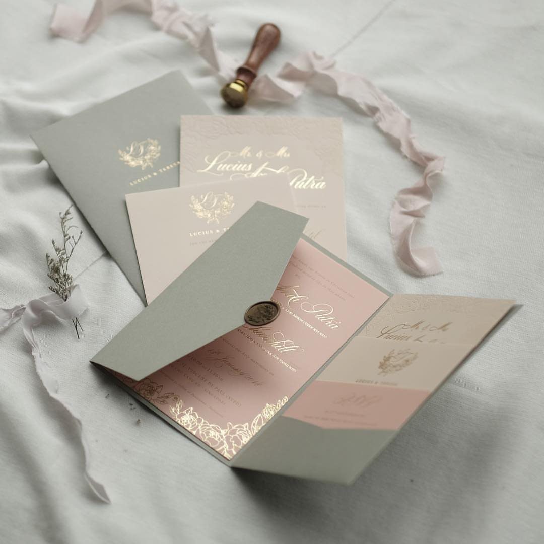 Wedding invitation set with a sage green pocket folder and gold foil lettering.