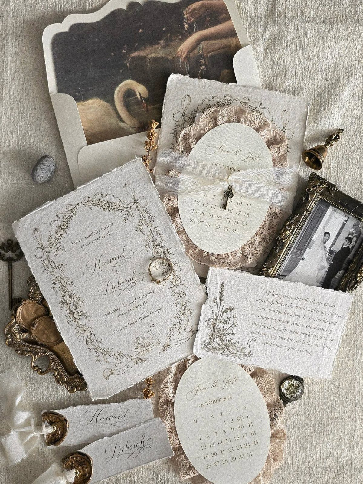 Cream wedding invitations with deckled edges and floral sketches among vintage photographs.