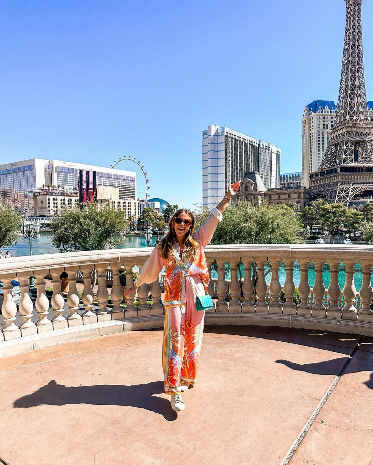 Woman wearing a pink and orange matching set posing before the Las Vegas Eiffel Tower