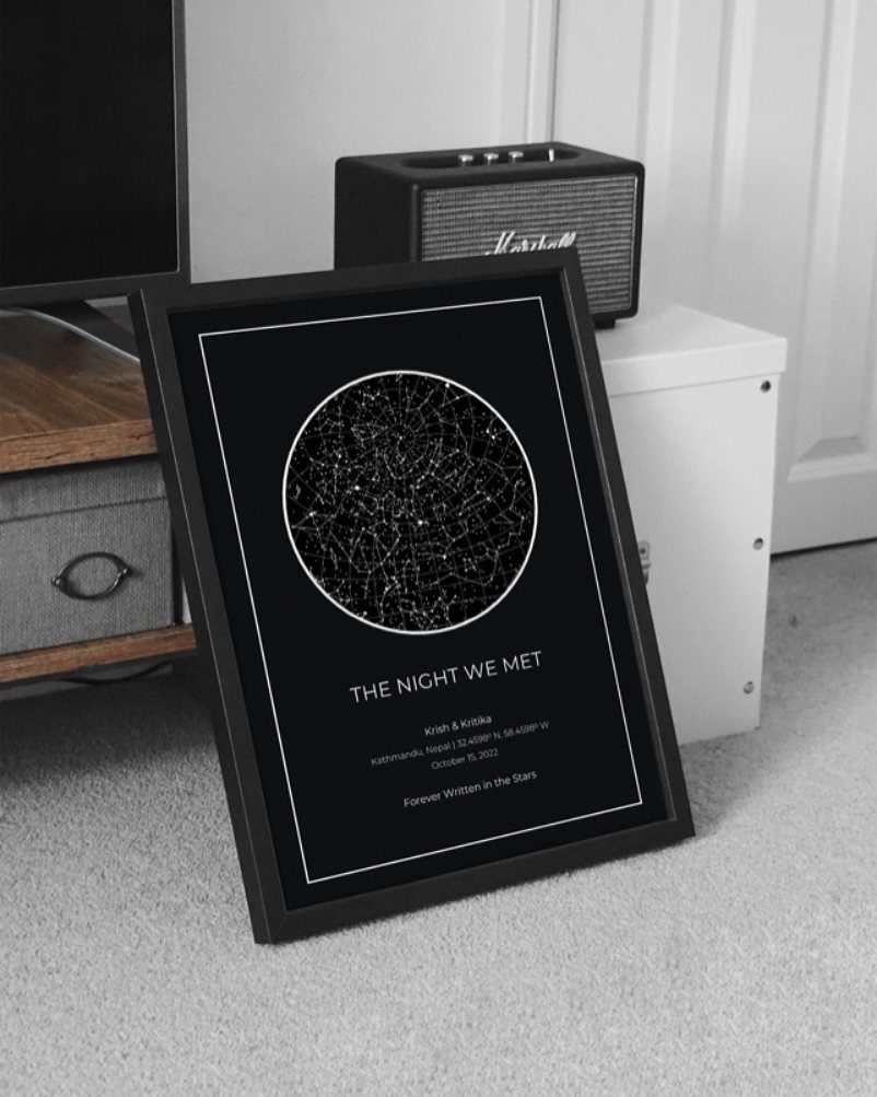 Framed star map print with the text The Night We Met on carpet.
