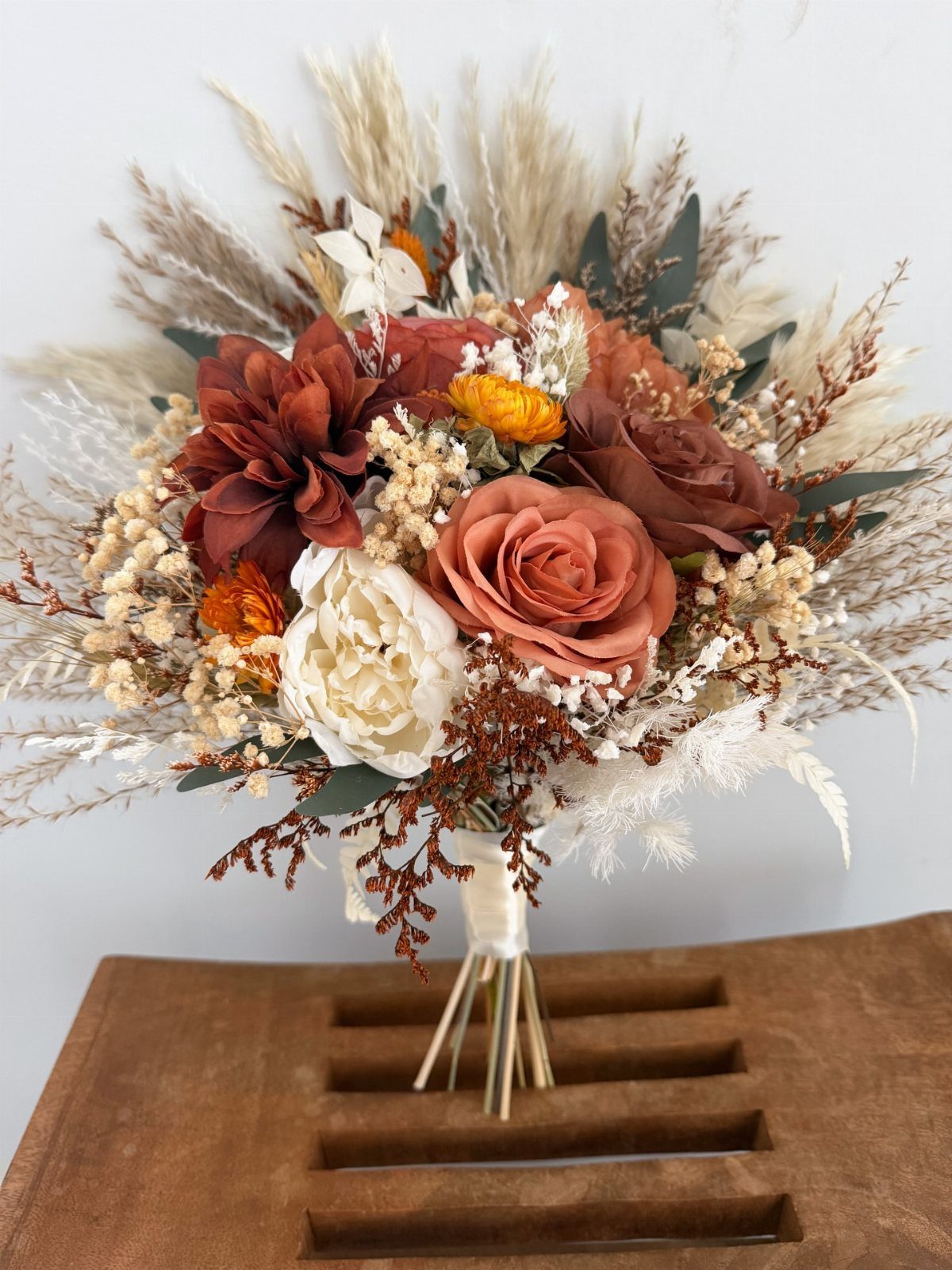 Bridal bouquet with dried rust and cream flowers and pampas grass foliage.