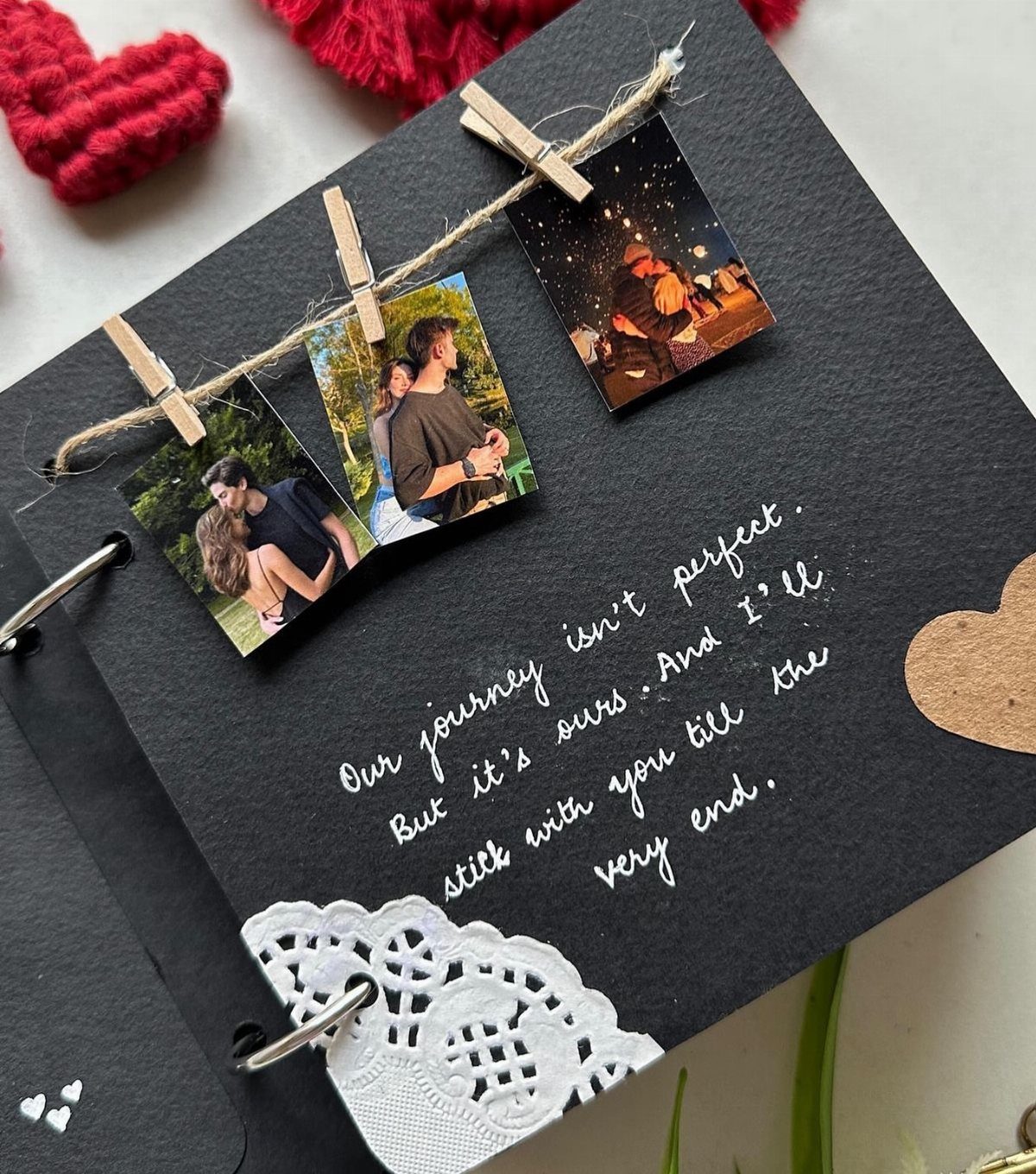 Scrapbook page with polaroid photos of a couple clipped to a twine string.